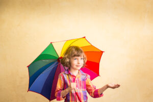 Kind schützt sich mit Regenschirm